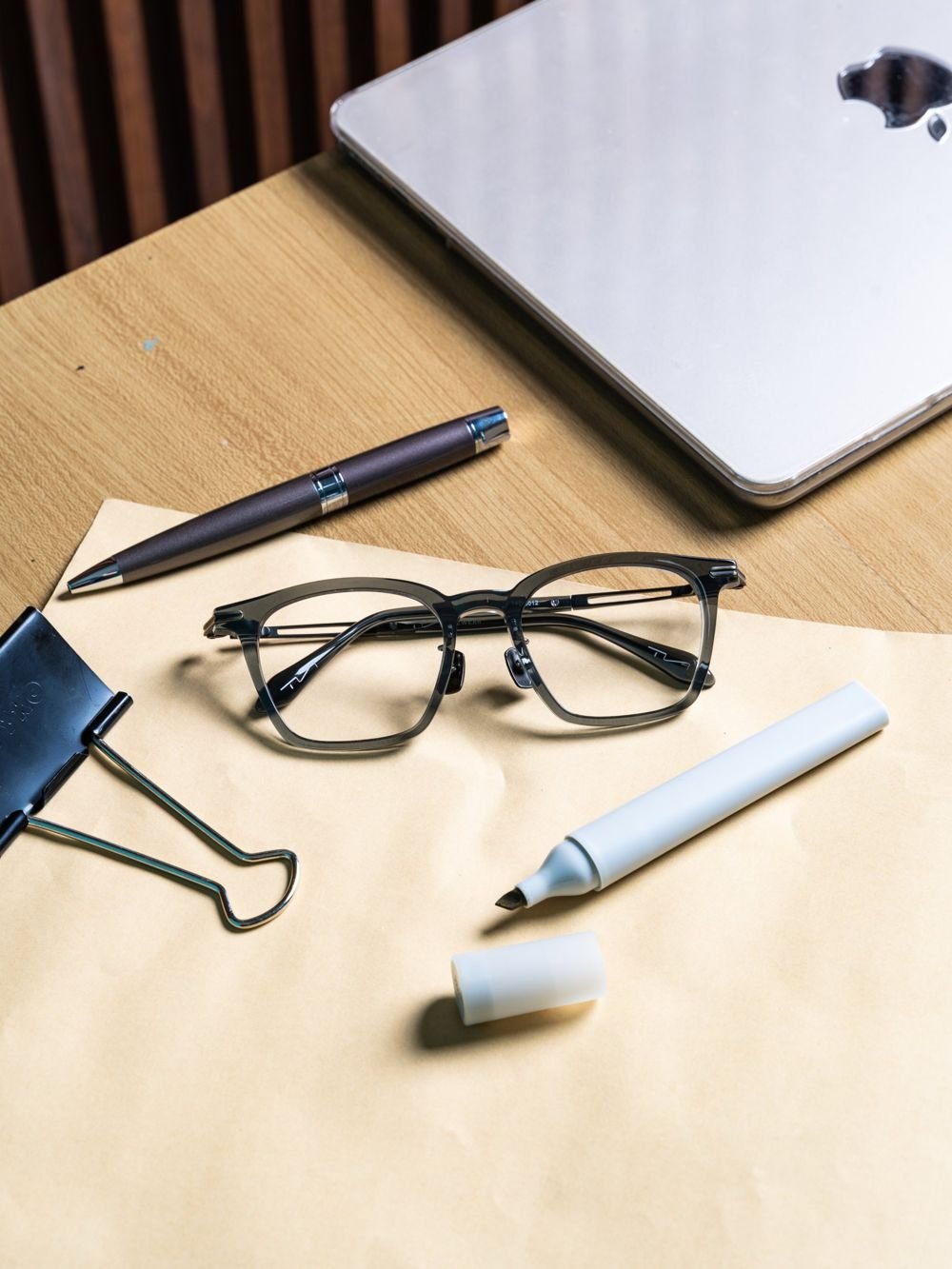 Grey frames on a desk with a pen, clip and marker