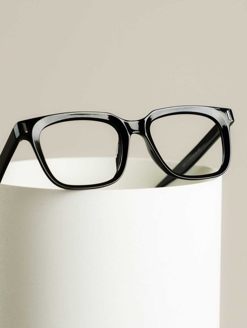 Black frames resting on a white pedestal