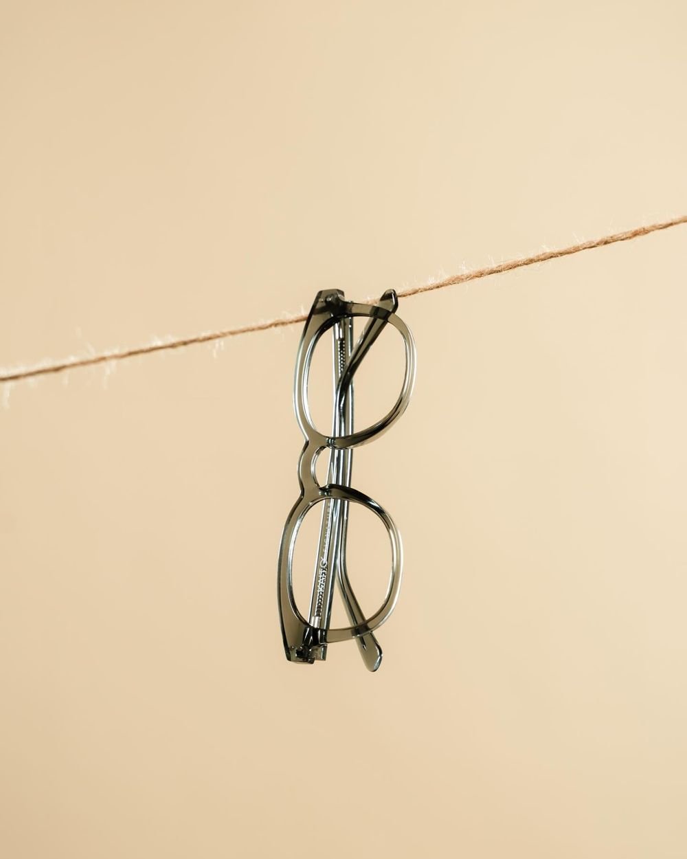 Clear grey frames hanging from a twine line